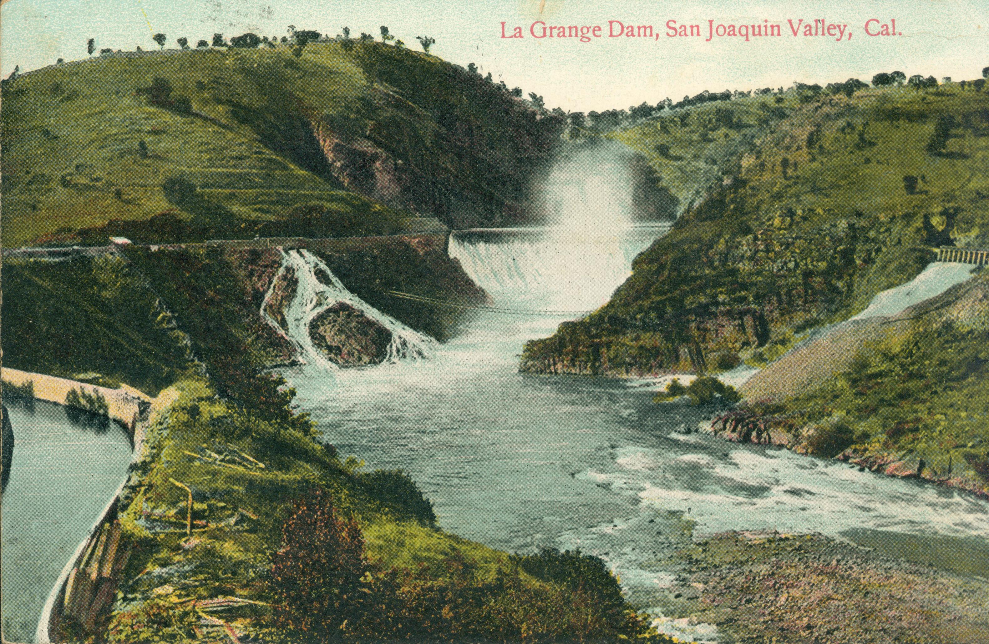 Shows La Grange dam releasing water, with an irrigation canal of to the left